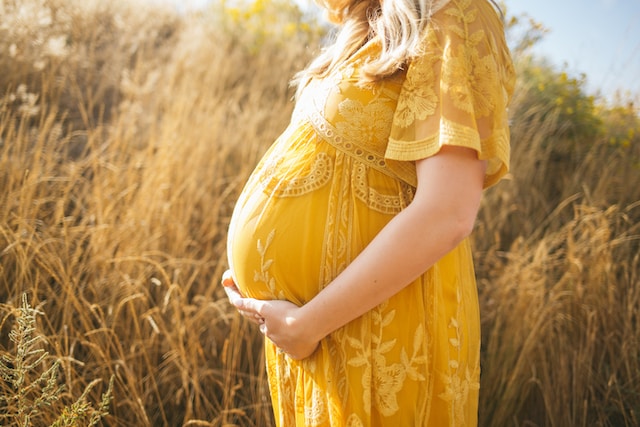 Беременная женщина в желтом платье