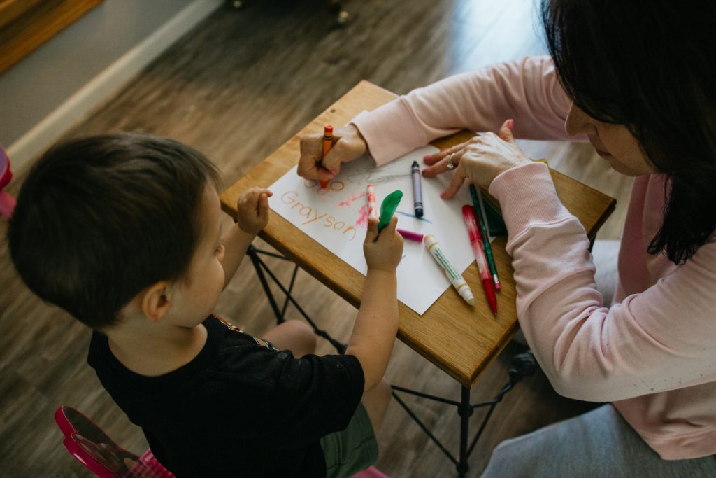 Ребенок рисует за столиком с мамой